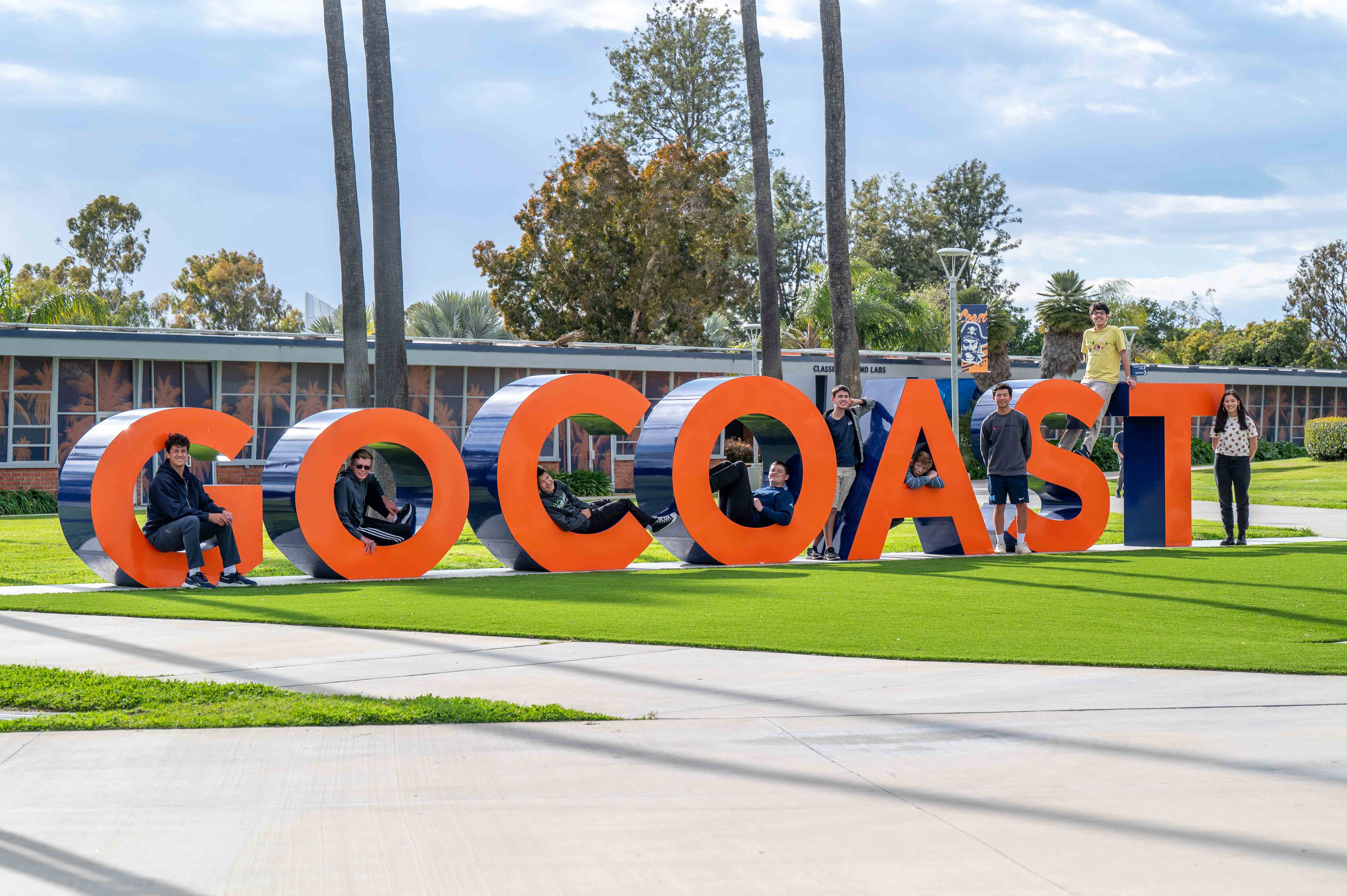 Participating high school students pose alongside the GO Coast letters in the main quad